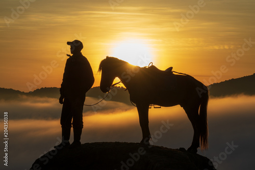 BROMO, INDONESIA - 16th APRIL 2018; Silhouette of unidentified local people or Bromo Horseman at the mountainside of Mount Bromo, Semeru, Tengger National Park, East Java of Indonesia. photo
