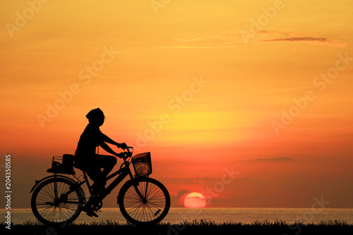 Silhouette man and bike relaxing on sunrise