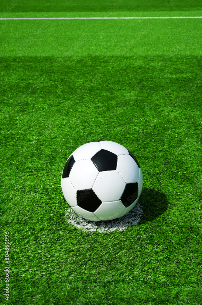 Fussball auf Elfmeterpunkt, grüner Kunstrasen in der Sonne im Sommer Fussball auf Elfmeterpunkt, grüner Kunstrasen in der Sonne im Sommer