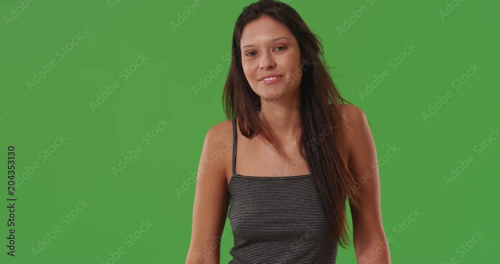 Beautiful young woman laughing and casually standing on greenscreen Beautiful young woman laughing and casually standing on greenscreen