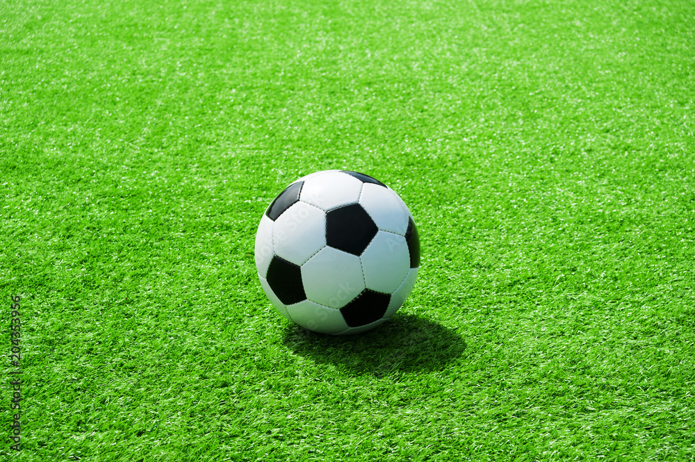 Fussball auf grünem Kunstrasen, klassich mit viel Platz für Text Fussball auf grünem Kunstrasen, klassich mit viel Platz für Text