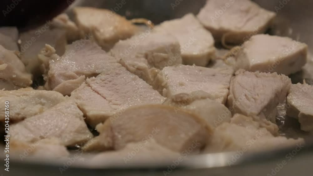 Raw chicken meat in the frying pan close-up video - Cuts of poultry on hot oil Raw chicken meat in the frying pan close-up video - Cuts of poultry on hot oil