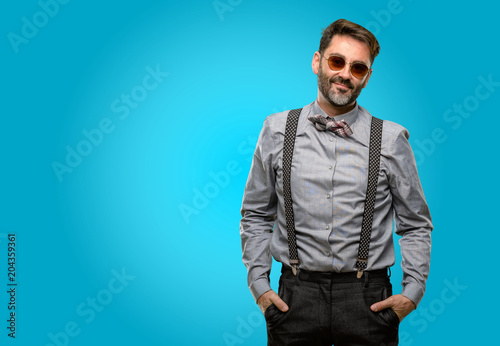Middle age man, with beard and bow tie confident and happy with a big natural smile looking at camera