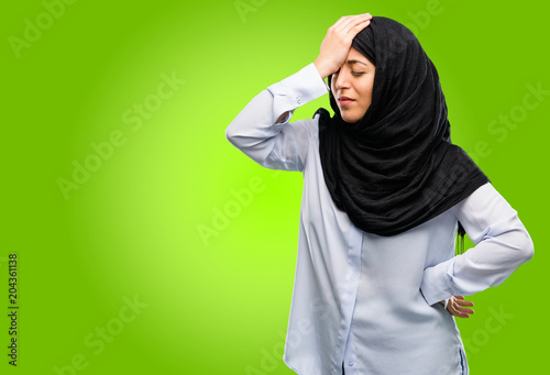 Young arab woman wearing hijab stressful keeping hand on head, tired and frustrated