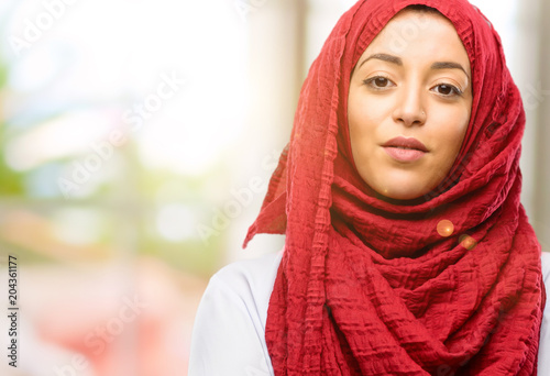 Young arab woman wearing hijab with crossed arms confident and happy with a big natural smile laughing