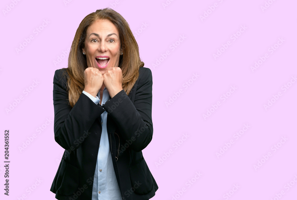 Middle age business woman happy and surprised cheering expressing wow gesture Middle age business woman happy and surprised cheering expressing wow gesture