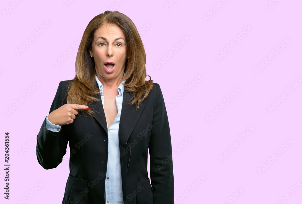 Middle age business woman happy and surprised cheering expressing wow gesture, pointing with finger Middle age business woman happy and surprised cheering expressing wow gesture, pointing with finger