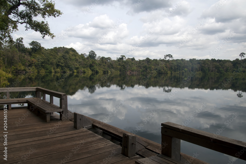 Banlung Cambodia, view of Yeak Lom lake from wooden pier with reflection of sky in water