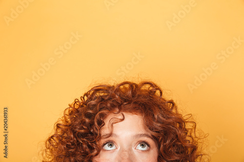 Half face of young woman looking up at copy space