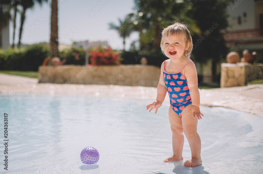 Little cute blonde baby girl infant in swimming pool Stock Photo