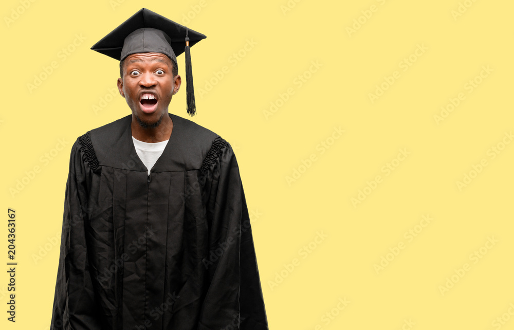 Young african graduate student black man stressful, terrified in panic, shouting exasperated and frustrated. Unpleasant gesture. Annoying work drives me crazy Young african graduate student black man stressful, terrified in panic, shouting exasperated and frustrated. Unpleasant gesture. Annoying work drives me crazy