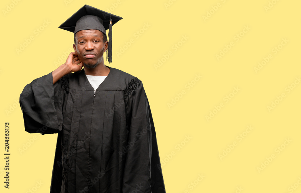 Young african graduate student black man doubt expression, confuse and wonder concept, uncertain future Young african graduate student black man doubt expression, confuse and wonder concept, uncertain future