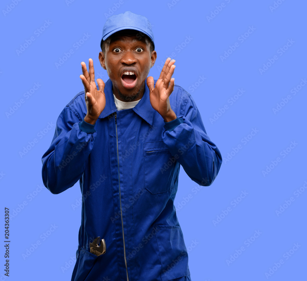 African black plumber man stressful keeping hands on head, terrified in panic, shouting African black plumber man stressful keeping hands on head, terrified in panic, shouting
