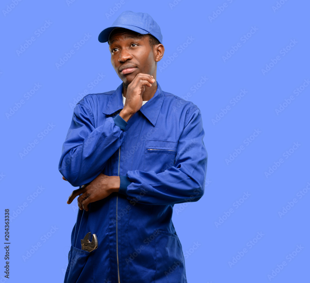 African black plumber man thinking and looking up expressing doubt and wonder