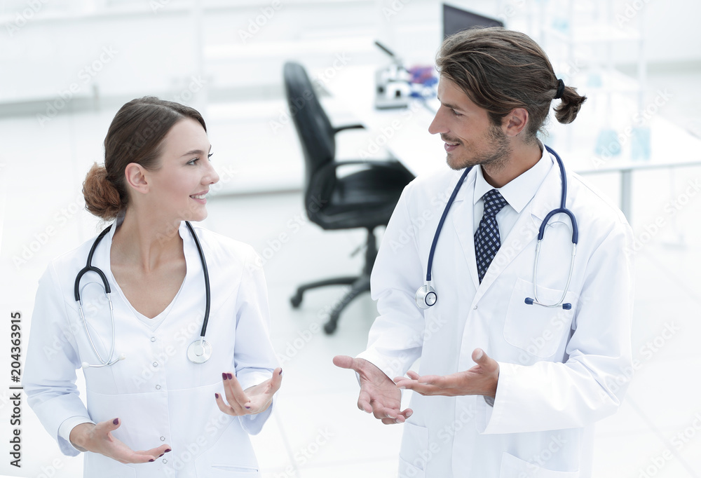 Two Doctors Having Meeting In Hospital Reception Area Two Doctors Having Meeting In Hospital Reception Area