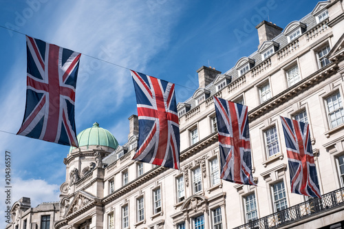 Close up of buildings on Regent Street London UK photographed from street level, with row of British flags to celebrate the Royal Wedding of Prince Harry to Meghan Markle.