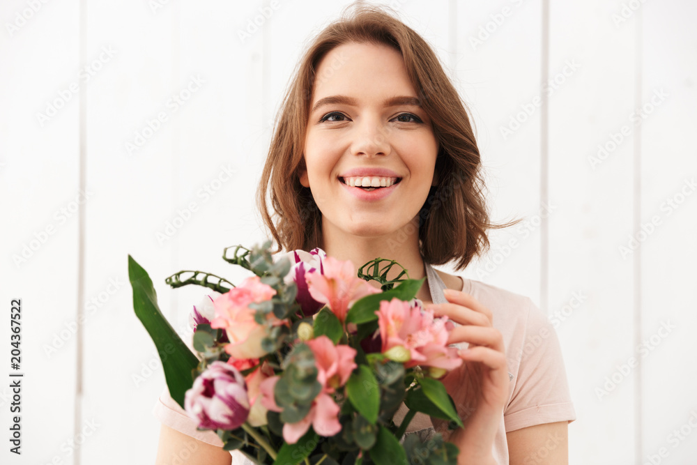 Happy florist woman standing with flowers Happy florist woman standing with flowers