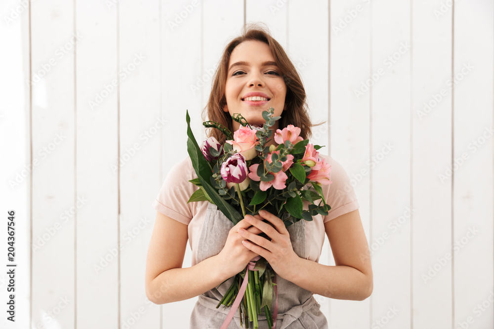 Happy florist woman standing with flowers Happy florist woman standing with flowers