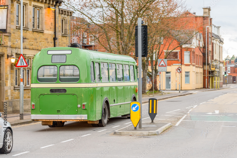 Green retro bus on British road in England