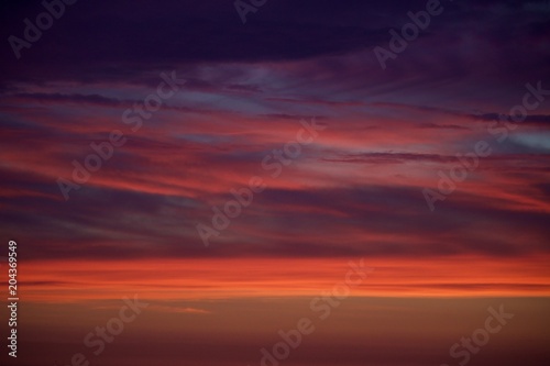 Nuvens vermelhas com o reflexo do sol ao fim da tarde. Pôr-do-sol. © Silvano Rego