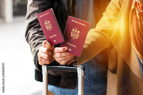 Red Moldavian biometric passport id to travel the Europe without visas. Modern passport with electronic chip let Moldavians travel to European Union without visa. Hands holding passports photo