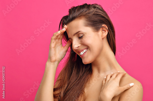 Beautiful woman posing against pink background
