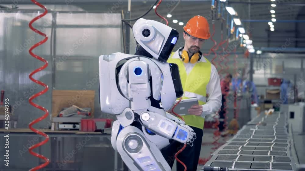 Drilling process performed by a cyborg is being controlled by a factory employee Drilling process performed by a cyborg is being controlled by a factory employee