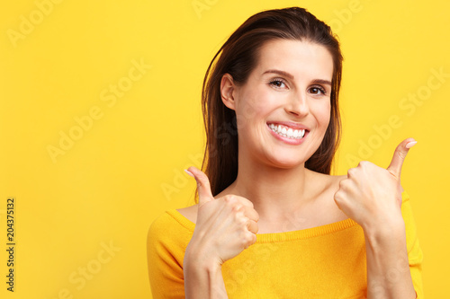Woman against yellow wall background
