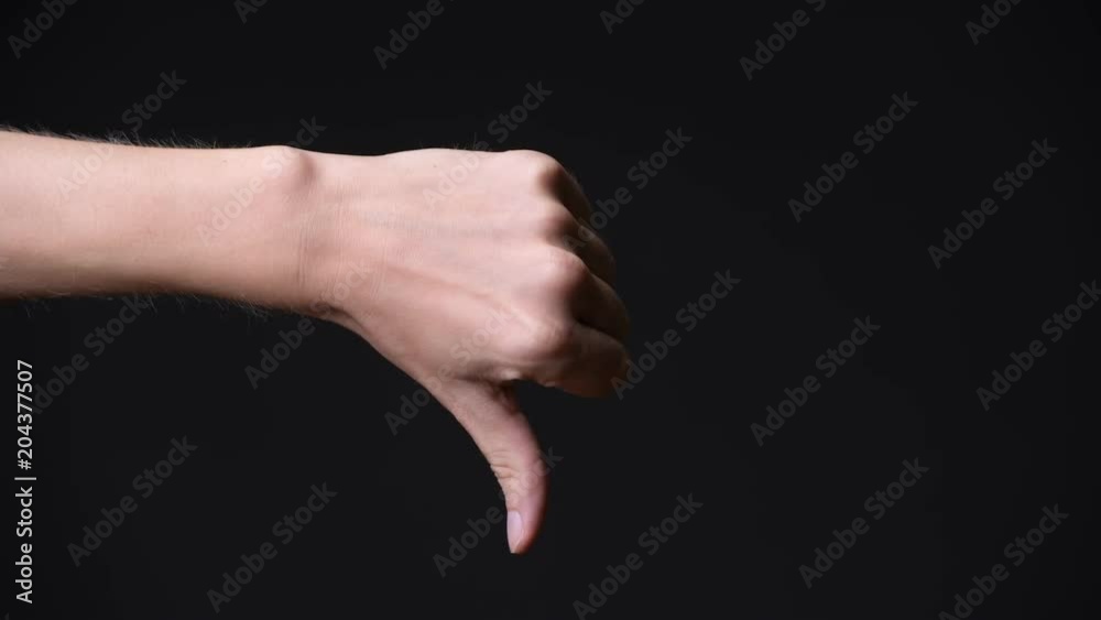 Hand of young man giving thumbs down Hand of young man giving thumbs down