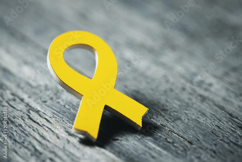 yellow ribbon on a wooden surface photo