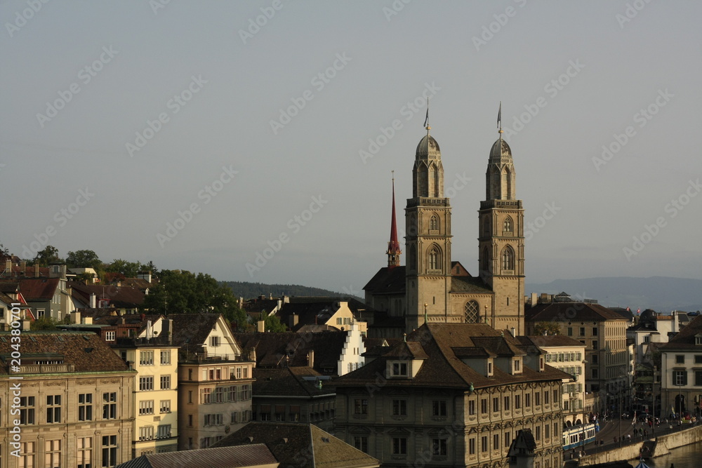 view of Zurich old city, Switzerland, including church towers and historical buildings on a sunny afternoon.