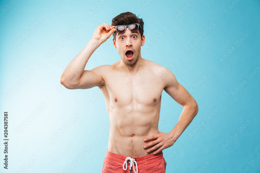 Portrait of a shocked young man in swimming shorts