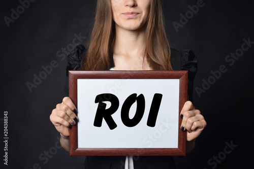 In the hands of a businessman a frame with the inscription:ROI