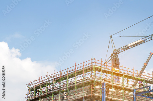 Lots of tower Construction site with cranes and building with blue sky background,scaffolding for construction factory