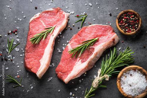 Raw beef striploin steak with herbs and spices. 