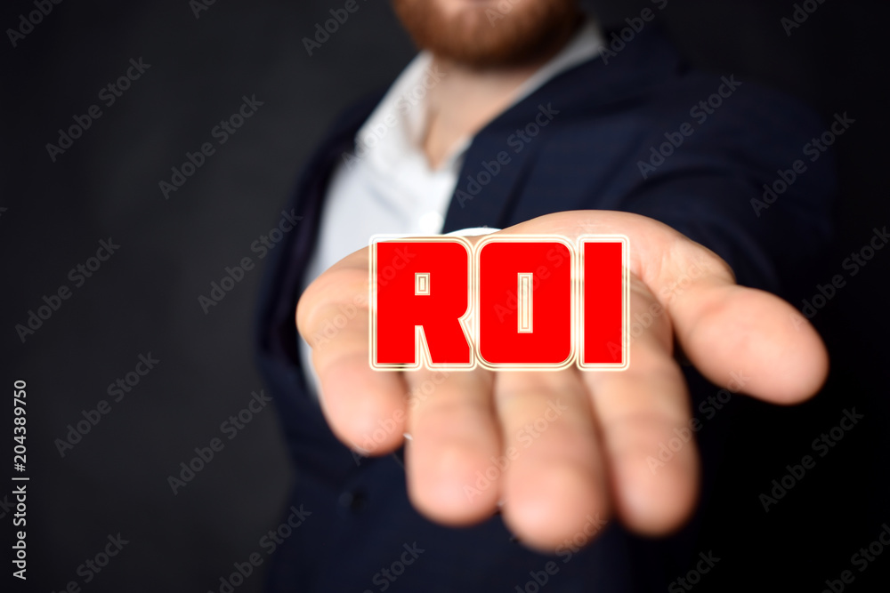 In the hands of a businessman the inscription:ROI In the hands of a businessman the inscription:ROI