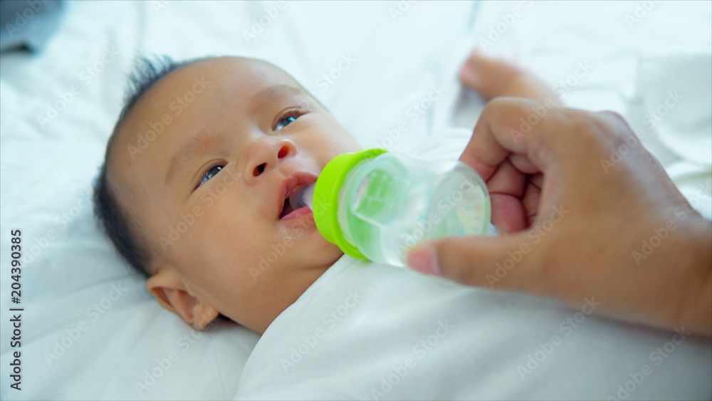 Little boy smiling during sucking water from bottle Little boy smiling during sucking water from bottle