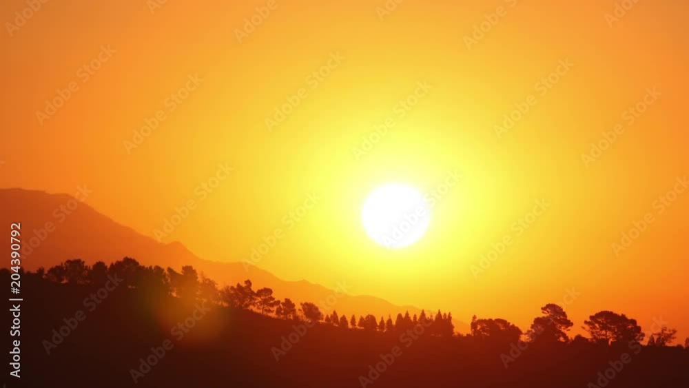 Time lapse of the sun rising behind low mountains Time lapse of the sun rising behind low mountains