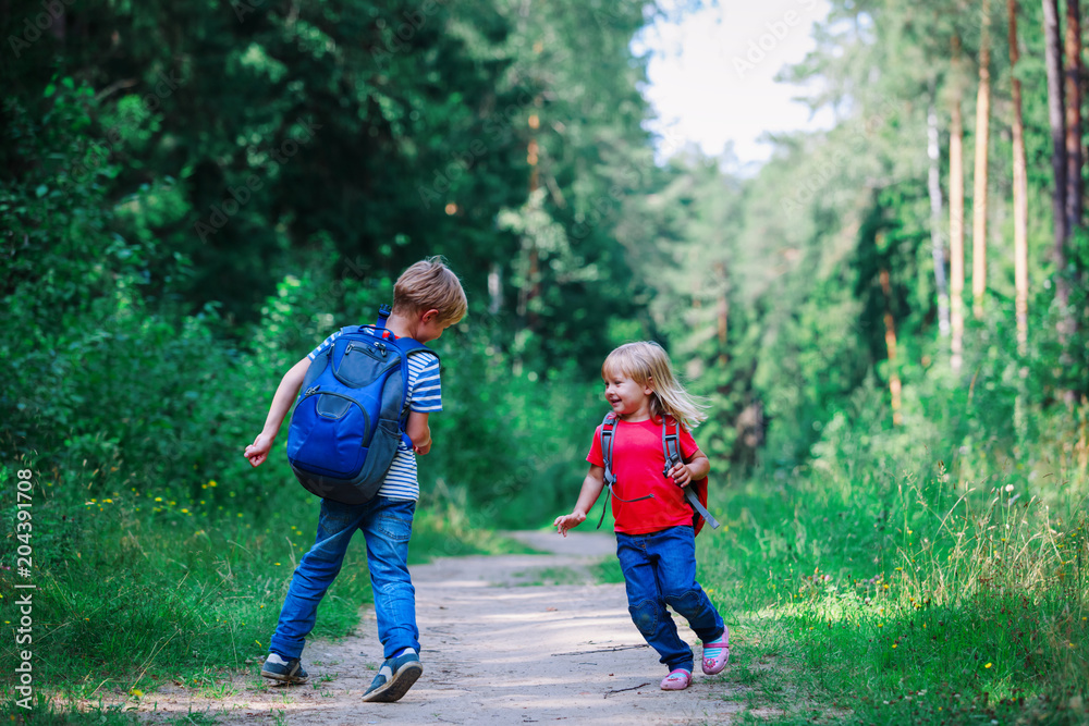 happy little boy and girl with backpacks in nature, school holidays happy little boy and girl with backpacks in nature, school holidays
