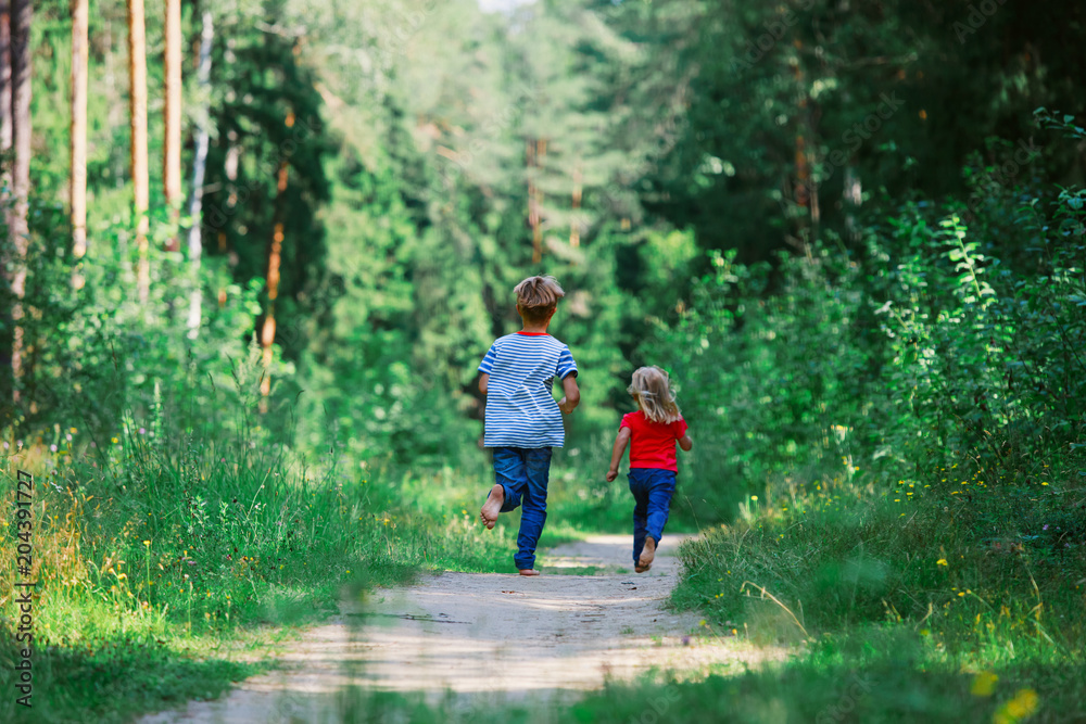 Obraz premium happy little girl and boy run play in nature