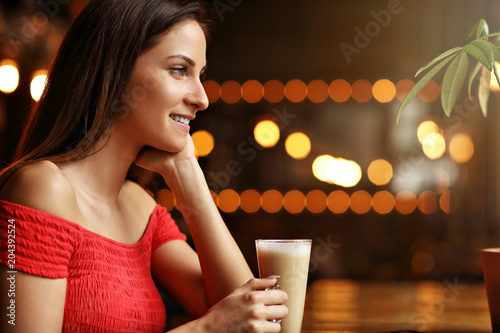 Young woman drinking coffee in a cafe photo