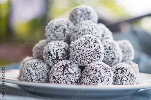 Sweet vegan coconut balls with chocolate, dates, coconut oil, bananas. Indian traditional dessert. Energy bars. Raw vegetarian healthy food