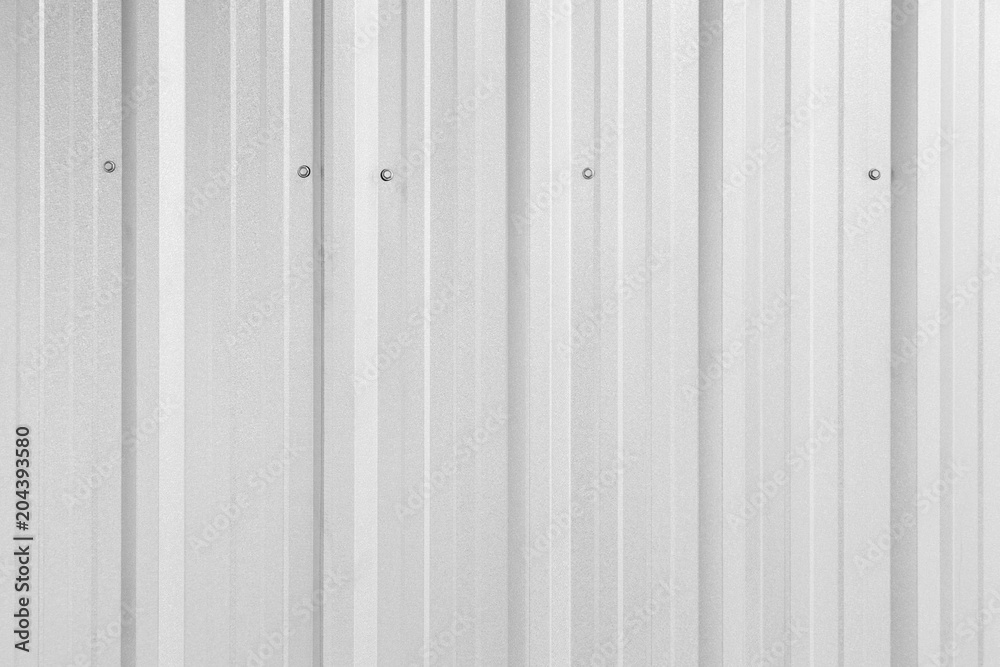Obraz premium Close-up of a shiny corrugated galvanized metal wall texture background in black and white. Full frame.
