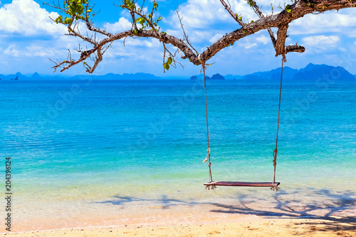 wooden swing on the tropical beach with clear water and blue sky paradise for vacation