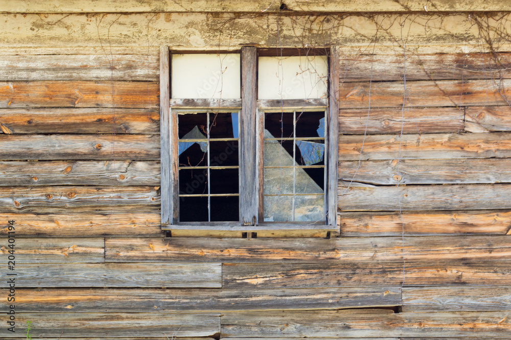 Old broken windows with shattered glass in a rustic wooden building. Old broken windows with shattered glass in a rustic wooden building.