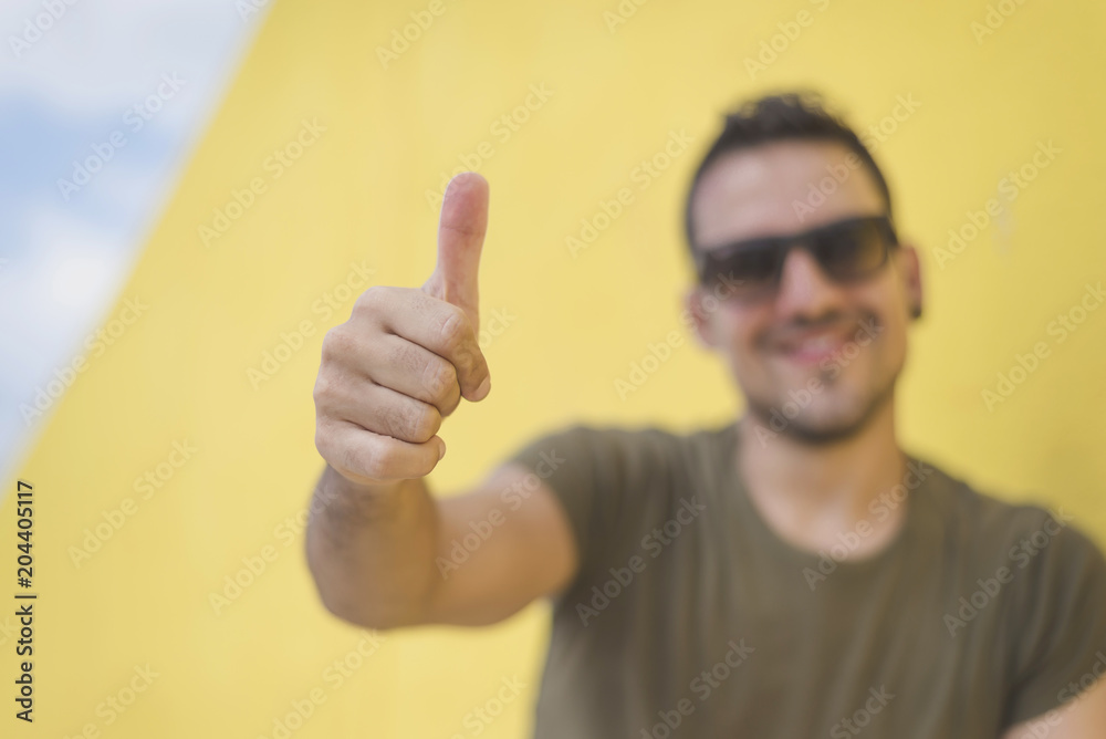 young man showing okay gesture wearing sunglasses young man showing okay gesture wearing sunglasses