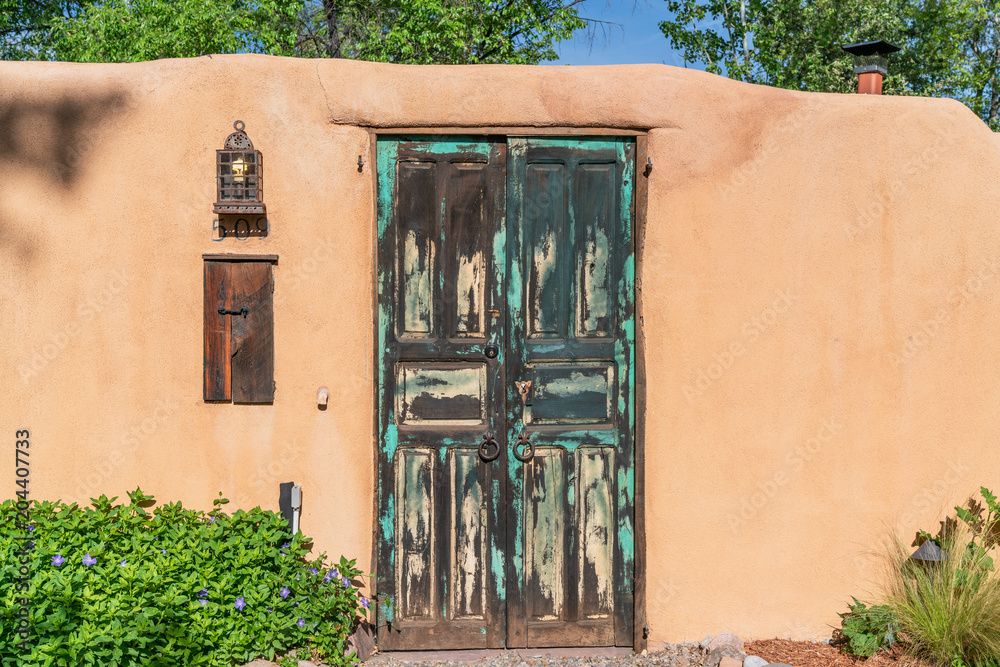 Fototapeta premium adobe wall with blue wooden gate santa fe new mexico