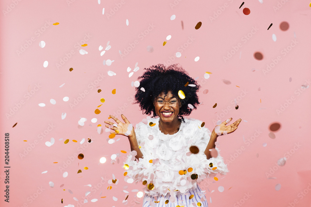 Celebrating happiness, young woman with big smile throwing confetti Celebrating happiness, young woman with big smile throwing confetti