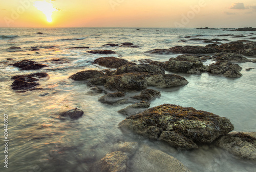 Sunset during low tide on Koh Lanta  Thailand. Algae covered rocks in shallow sea.