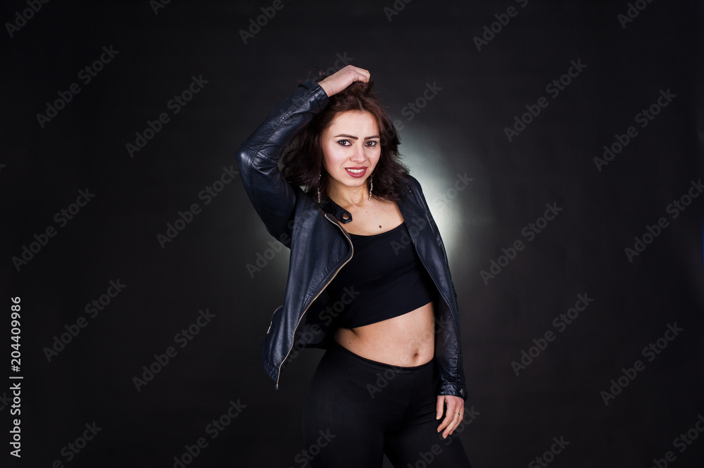 Studio portrait of sexy brunette girl in black leather jacket against black background. Studio portrait of sexy brunette girl in black leather jacket against black background.